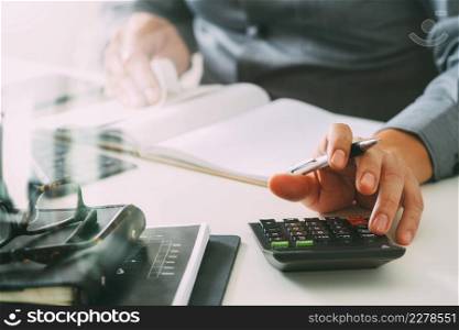 businessman hand working with finances about cost and calculator and latop with mobile phone on withe desk in modern office