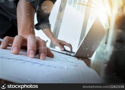 businessman hand working with new modern computer and business strategy documents digital layer with green plant and glass of water foreground on wooden desk in office
