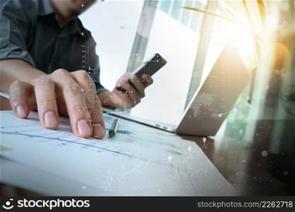 businessman hand working with new modern computer and business strategy documents digital layer with green plant and glass of water foreground on wooden desk in office