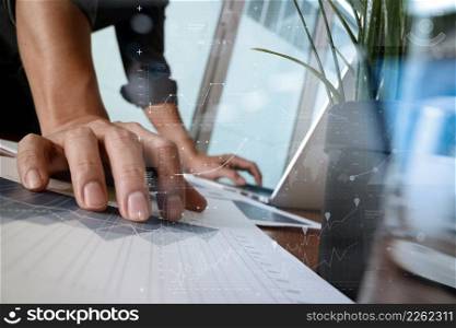 businessman hand working with new modern computer and business strategy documents layers with glass of water and greenplant foreground on wooden desk in office