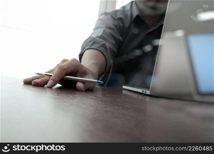businessman hand working with new modern computer and smart phone and business strategy on wooden desk as concept                        