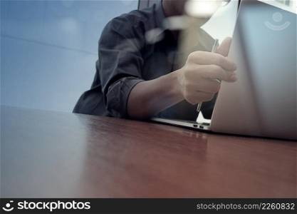 businessman hand working with new modern computer and smart phone and business strategy on wooden desk as concept
