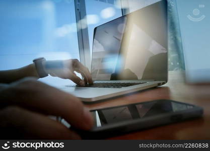 businessman hand working with new modern computer and smart phone and business strategy on wooden desk as concept  