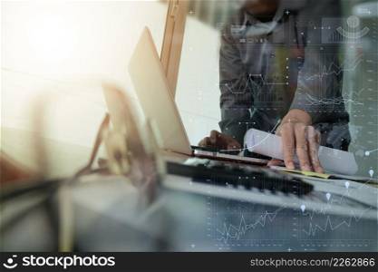 businessman hand working with new modern computer and smart phone and business strategy document on wooden desk with calculator and eyeglass foreground as concept