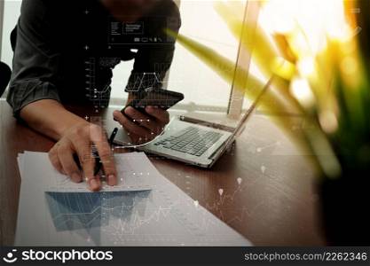 businessman hand working with new modern computer and smart phone with business strategy documents digital layers with green plant foreground on wooden desk in office
