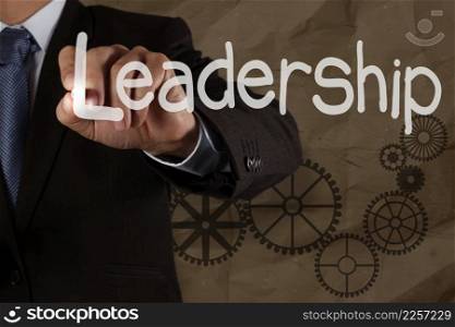 businessman hand writing leadership skill with gear on crumpled recycle bacground as concept