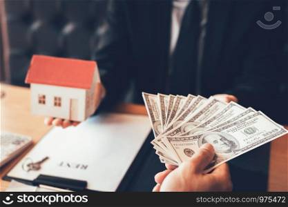Businessman handed the house model and new homeowner giving money to real estate trading.