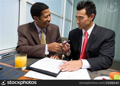 Businessman handing pen over to another businessman