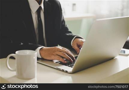 Businessman hands working on laptop,Blurred background .