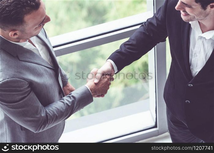 Businessman handshake with another businessman partner in modern workplace office. People corporate business deals concept.. Businessmen handshake business deal in office.