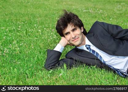 businessman has rest, lying on grass