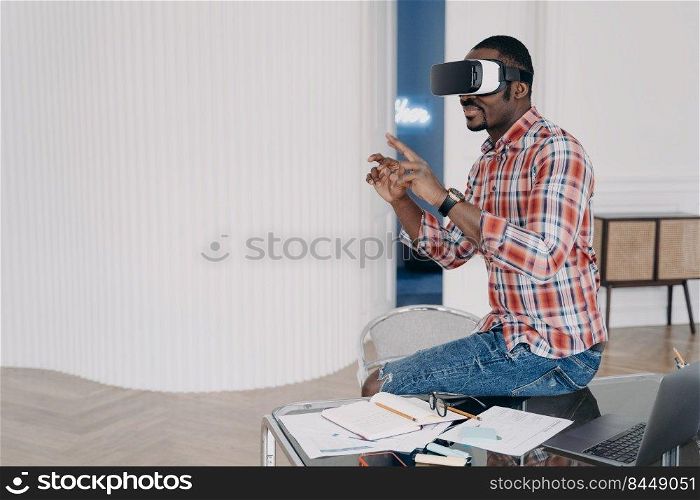 Businessman has virtual course. African american man in vr glasses at home. Virtual reality headset using, electronic device. Modern education and digital technology for business and creativity.. Businessman has virtual course. African american man is using vr glasses at home.