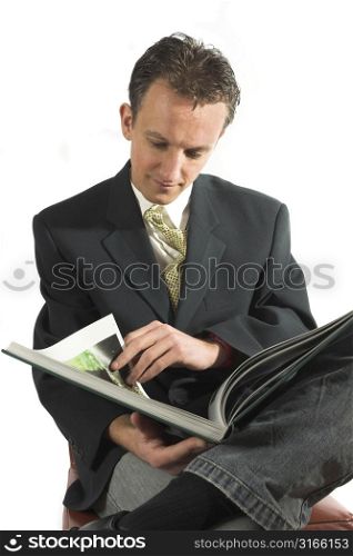 Businessman having a relaxing read with his tie loose
