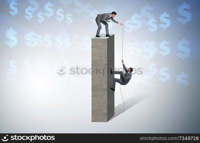 Businessman helping colleague with rope
