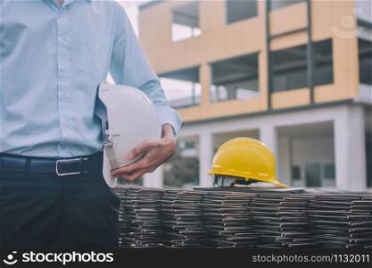 Businessman hold helmet hard hat safety construction background,Engineering project control