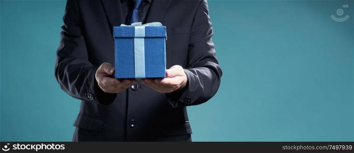 Businessman hold the present box to give somebody , holiday and christmas gift concept .