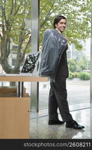Businessman holding a coat in an office