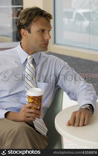 Businessman holding a coffee cup and thinking