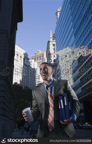 Businessman holding a disposable cup and laughing