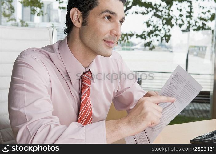 Businessman holding a form in an office