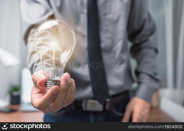 Businessman holding a light bulb and thinking of new ideas