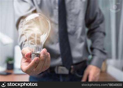 Businessman holding a light bulb and thinking of new ideas