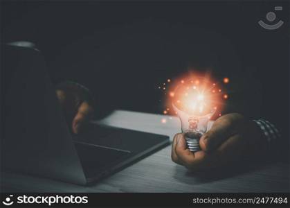 businessman holding a light bulb with a laptop computer.Digital creative design concept technology marketing.