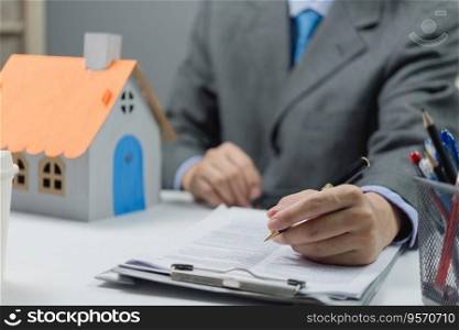 businessman holding a pen signing a house purchase contract. Real estate business concept land and rental, insurance and bank loan.