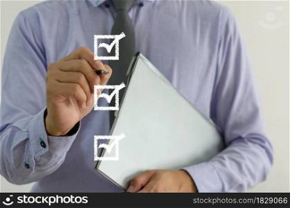 businessman holding a pen with a check mark on the square on a virtual screen