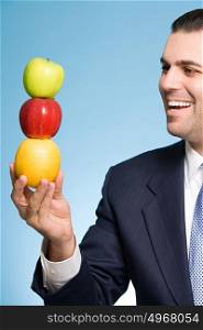 Businessman holding a stack of fruit