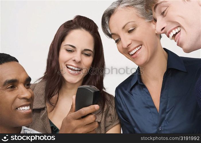 Businessman holding a telephone with three business executives smiling