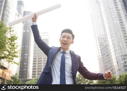 Businessman holding architectural drawings