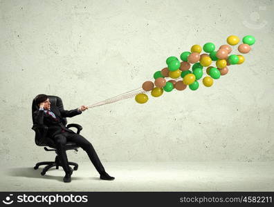 Businessman holding balloons. Image of businessman with bunch of color balloons