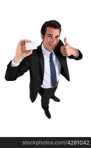Businessman holding card and making OK gesture