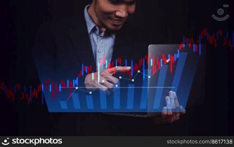 Businessman holding computer trading online or investment stock market with digital chart visual screen technology