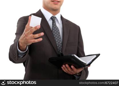 Businessman holding diary and offering business card