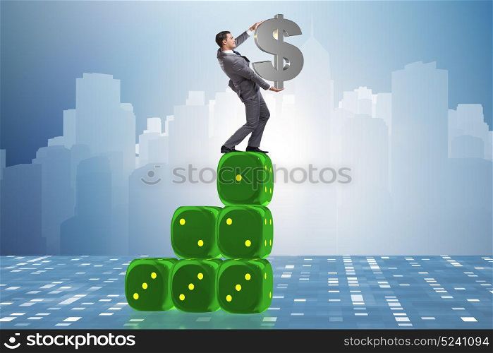 Businessman holding dollar sign on top of dice pyramid