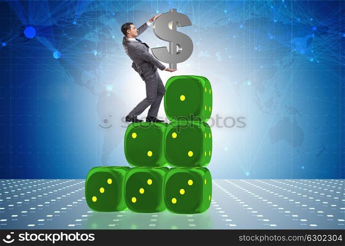 Businessman holding dollar sign on top of dice pyramid. The businessman holding dollar sign on top of dice pyramid