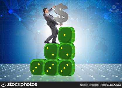 Businessman holding dollar sign on top of dice pyramid. The businessman holding dollar sign on top of dice pyramid