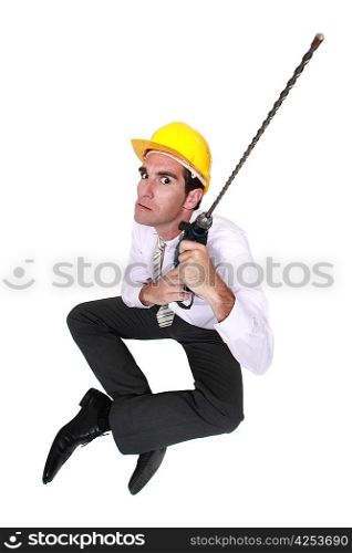 Businessman holding drill with long attachment