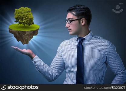 Businessman holding floating island with tree