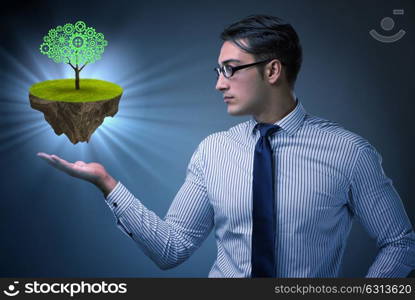 Businessman holding floating island with tree