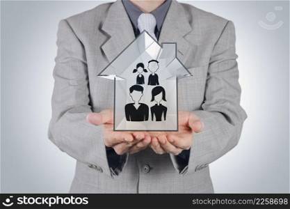 businessman holding hand drawn family icon and 3d house as insurance concept