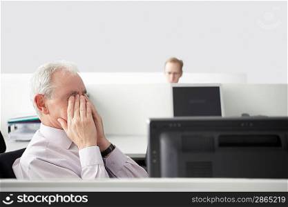 Businessman Holding Head in Hands