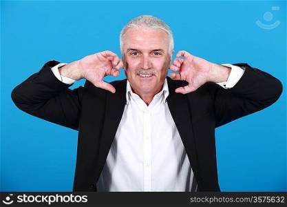 businessman holding his hands close to his ears