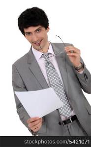 Businessman holding hiss glasses and sheet of paper