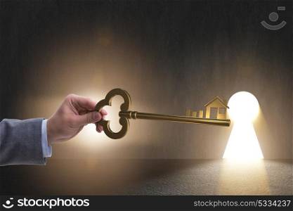 Businessman holding key in real estate concept