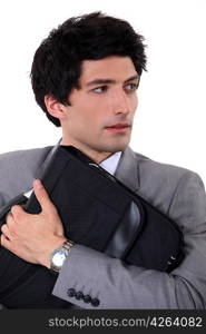 businessman holding laptop in his arms