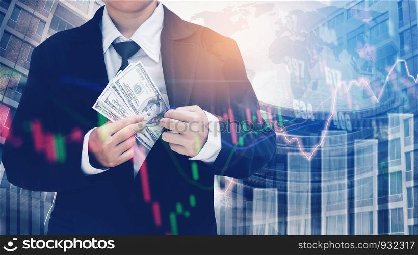 Businessman Holding money US dollar bills on digital stock market financial exchange and Trading graph Double exposure city on the background
