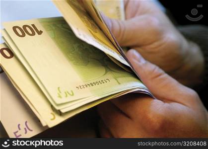 Businessman holding one hundred Euro banknotes